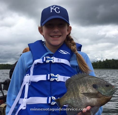 Girl holding bluegill on the boat