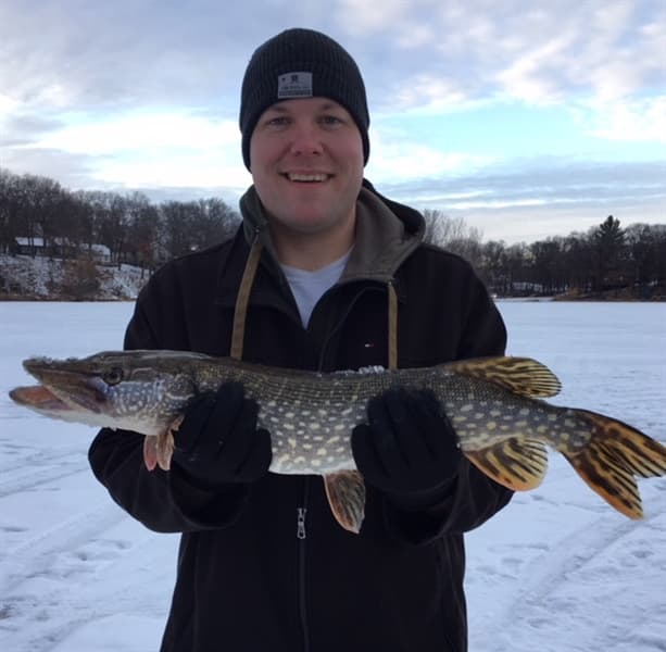 Angler with pike caught ice fishing
